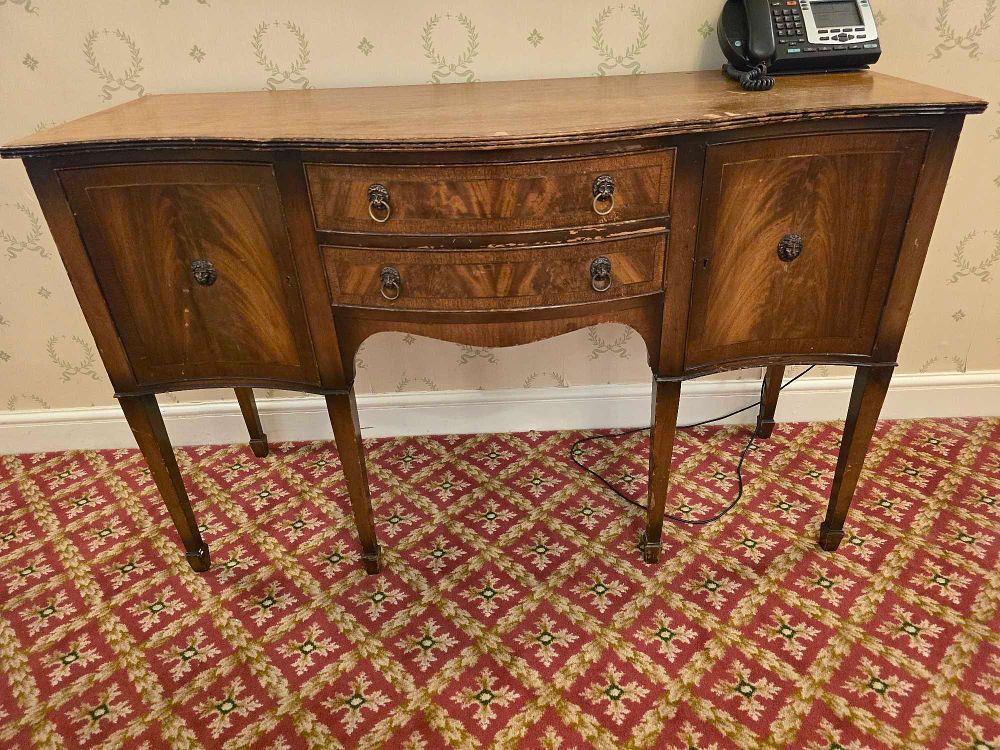 Lot 2163: An English Hepplewhite Style Flame Mahogany Serpentine Sideboard