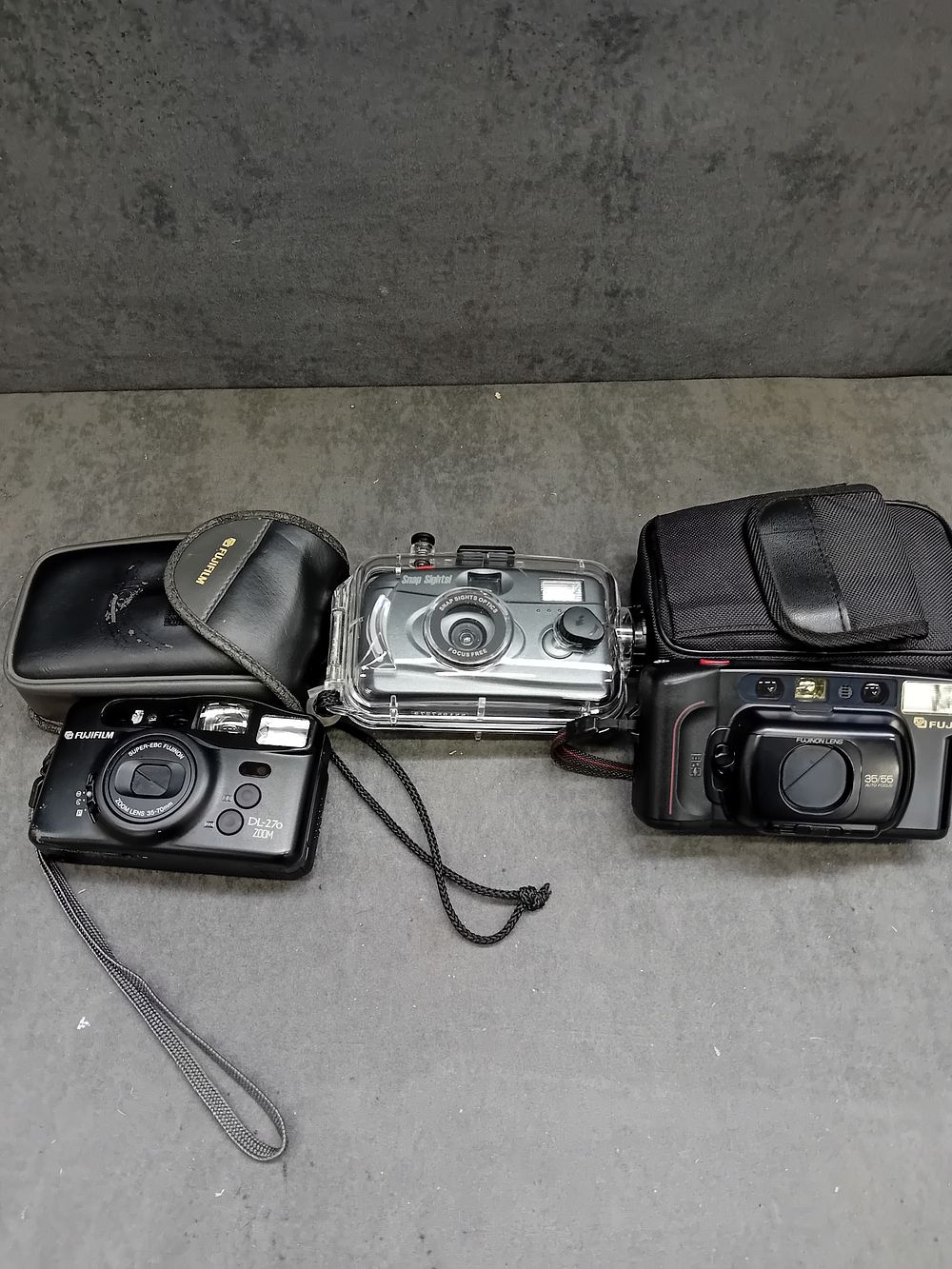 Lot 397: Three Cameras: Fujifilm Discovery DL-270 Zoom, Fujifilm DL-160 Tele, and Olympus Digital Camera in Snap Sights Casing
