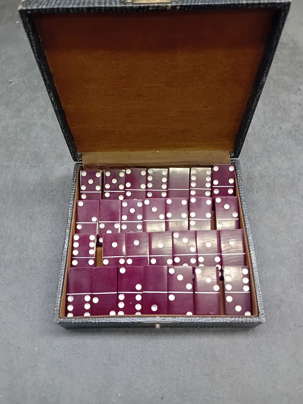 Lot 456: A Vintage Cased Set of Red Bakelite and Catalin Dominoes