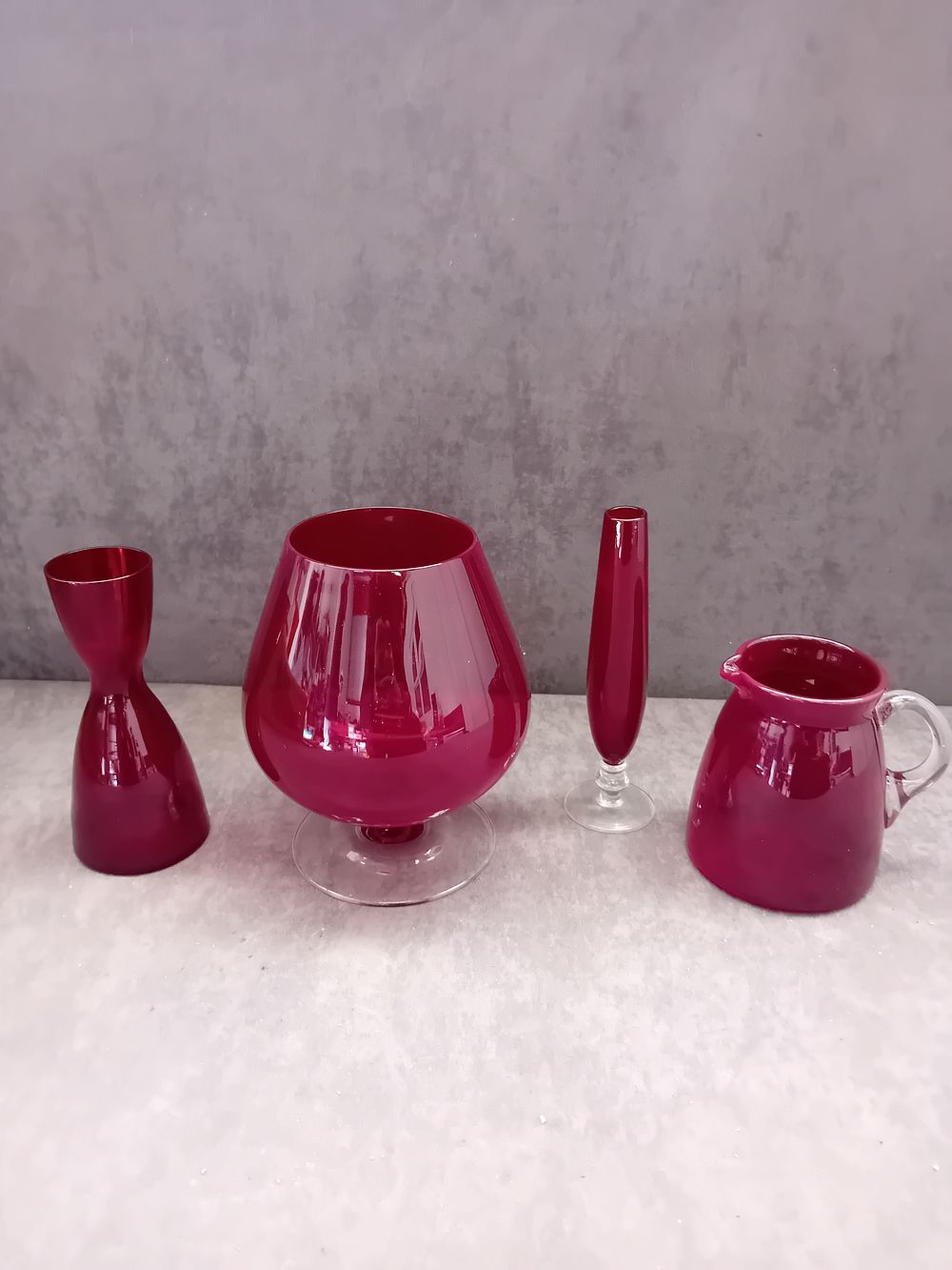 Lot 574: A Set of Four Mid-Century Modern Ruby Red Glass Decorative Vessels