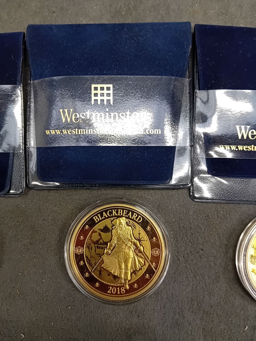 Lot 623: Three Modern Gold-Toned Numismatic Items by Westminster Collection, including 'Blackbeard' and 'Barbados Twenty Five Cents'