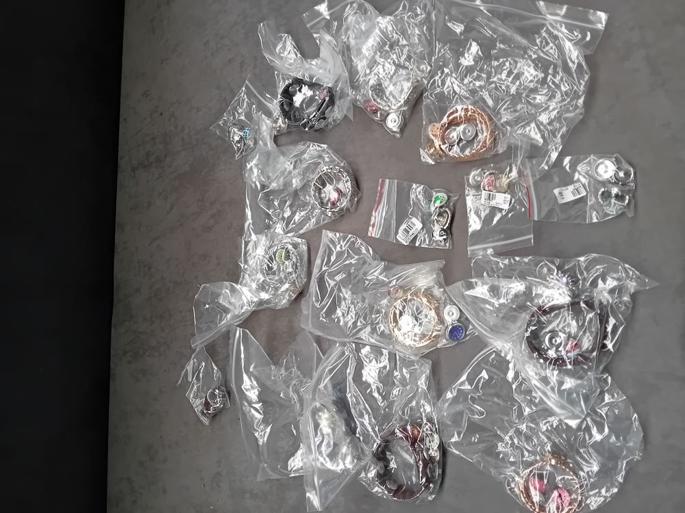 Lot 520: A Collection of 16 Individually Packaged Contemporary Costume Jewelry Items and Snap Charms