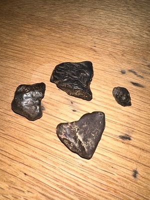 A Collection of Four Possibly Meteorite Rock Specimens and Educational Guide. The lot consists 