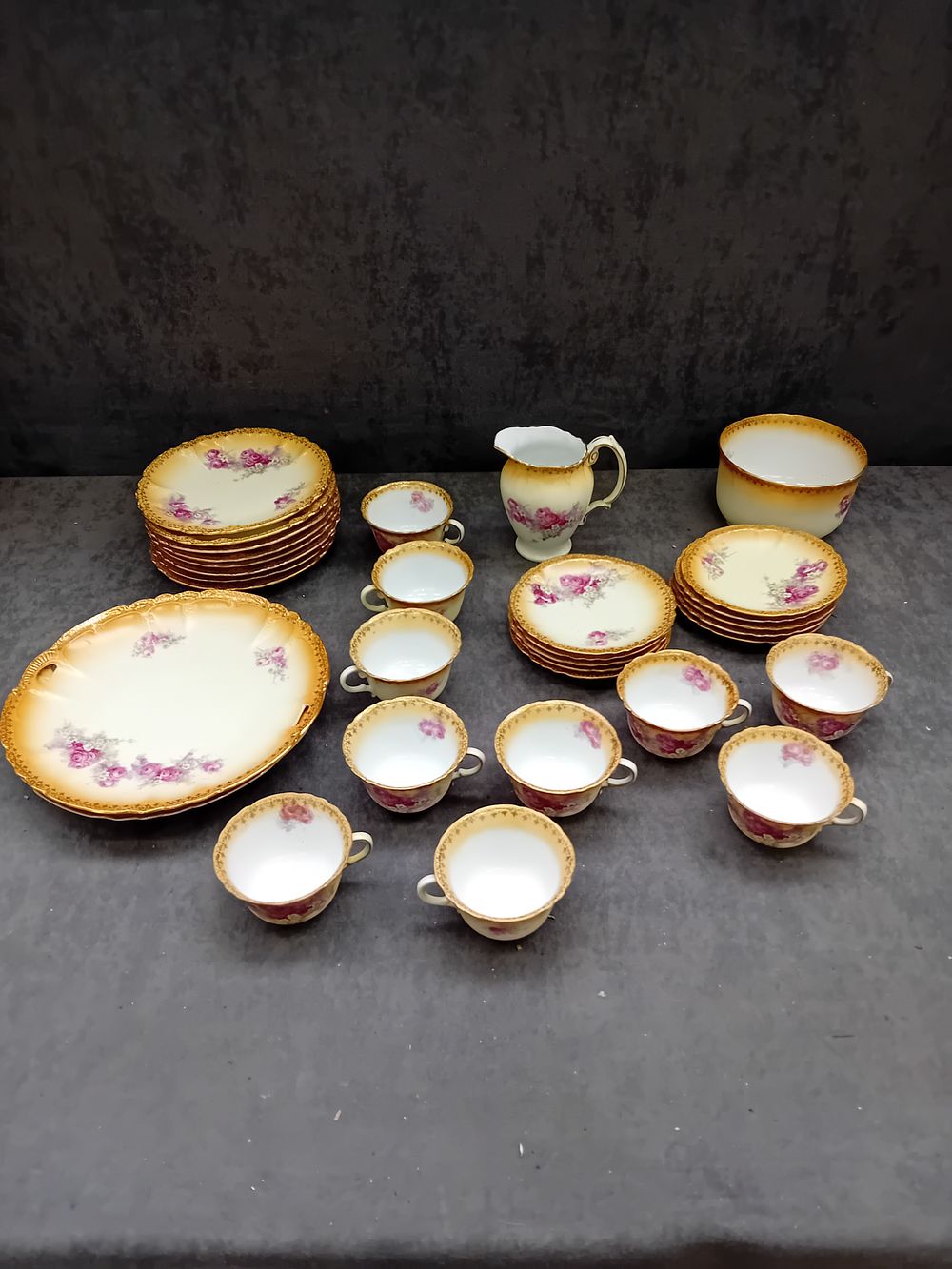 Lot 594: A Set of Porcelain Dinnerware with Rose Decoration and Gilt Rims