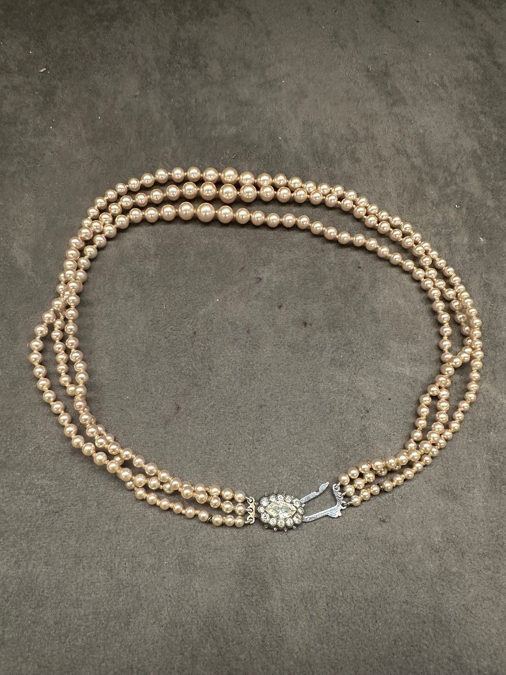 Lot 582: A Vintage Three-Strand Replica Pearl Necklace with Silver and Paste Clasp, marked 'LOTUS'