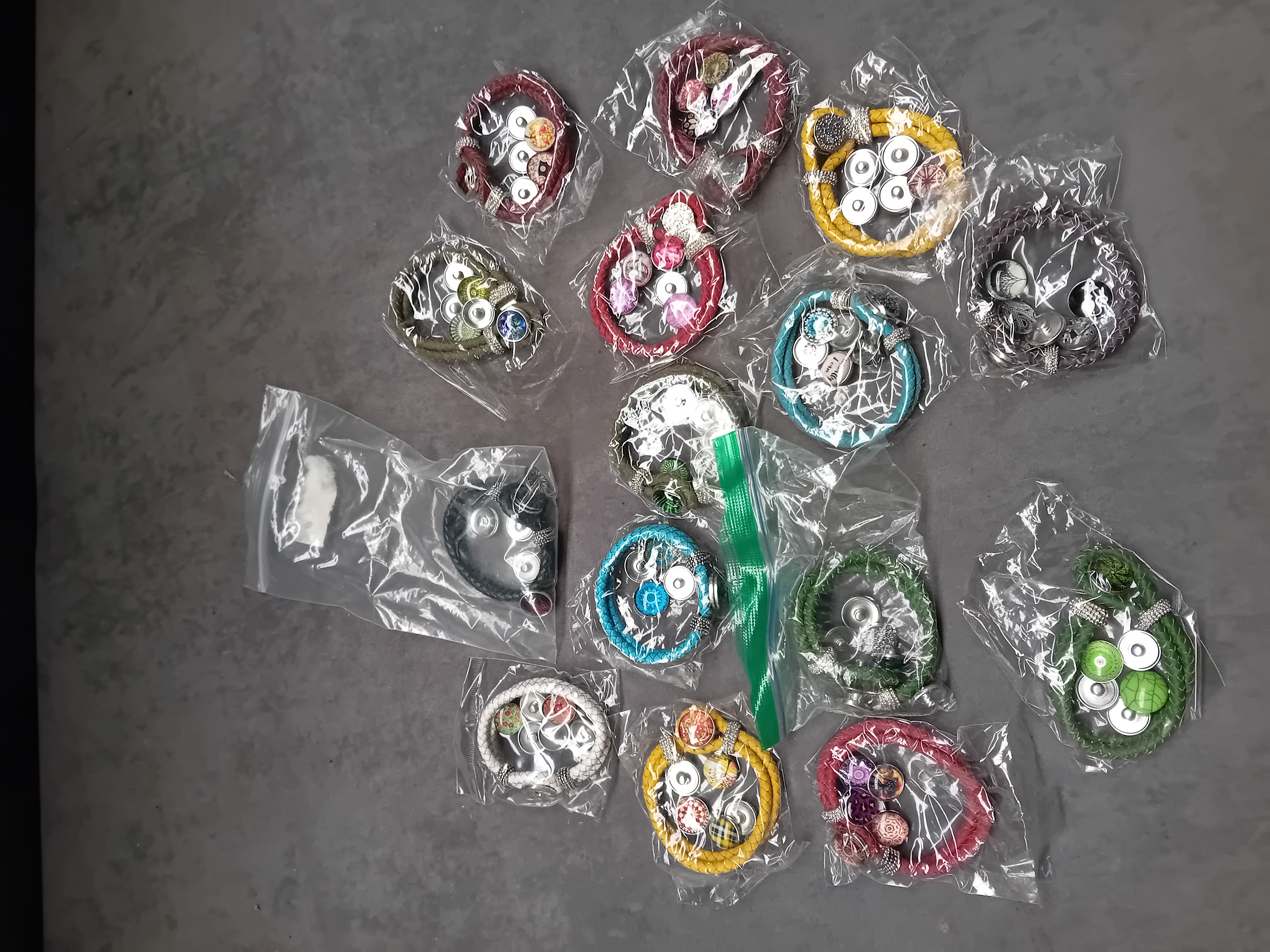 A Collection of 16 Contemporary Snap-Button Costume Bracelets with Interchangeable Rhinestone and Patterned Snaps
