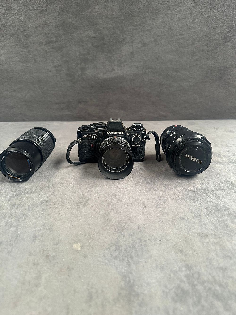 Lot 748: A Trio of Photographic Equipment Including an Olympus OM10 35mm SLR Camera and Two Zoom Lenses