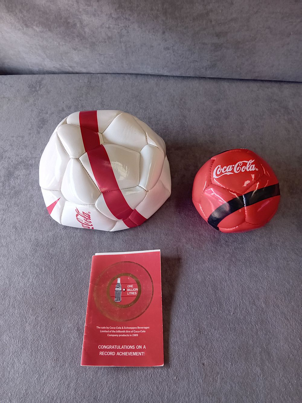 Lot 491: THREE COCA-COLA PROMOTIONAL ITEMS INCLUDING SOCCER BALLS AND TOKEN