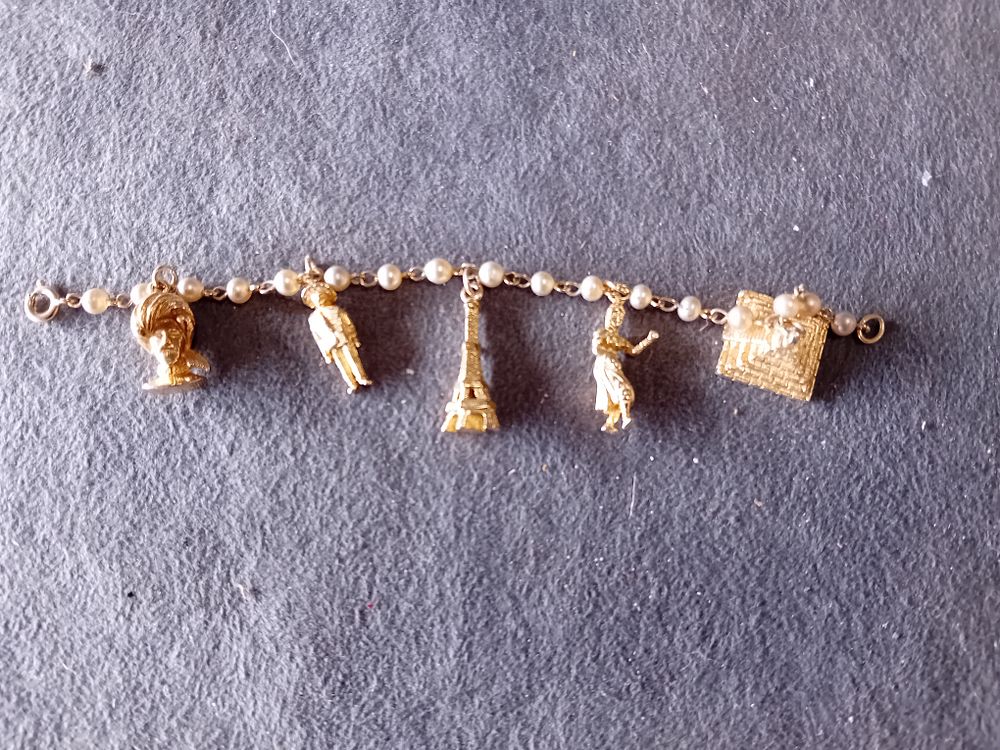 Lot 686: GOLD TONE CHARM BRACELET WITH FAUX PEARLS AND LANDMARKS
