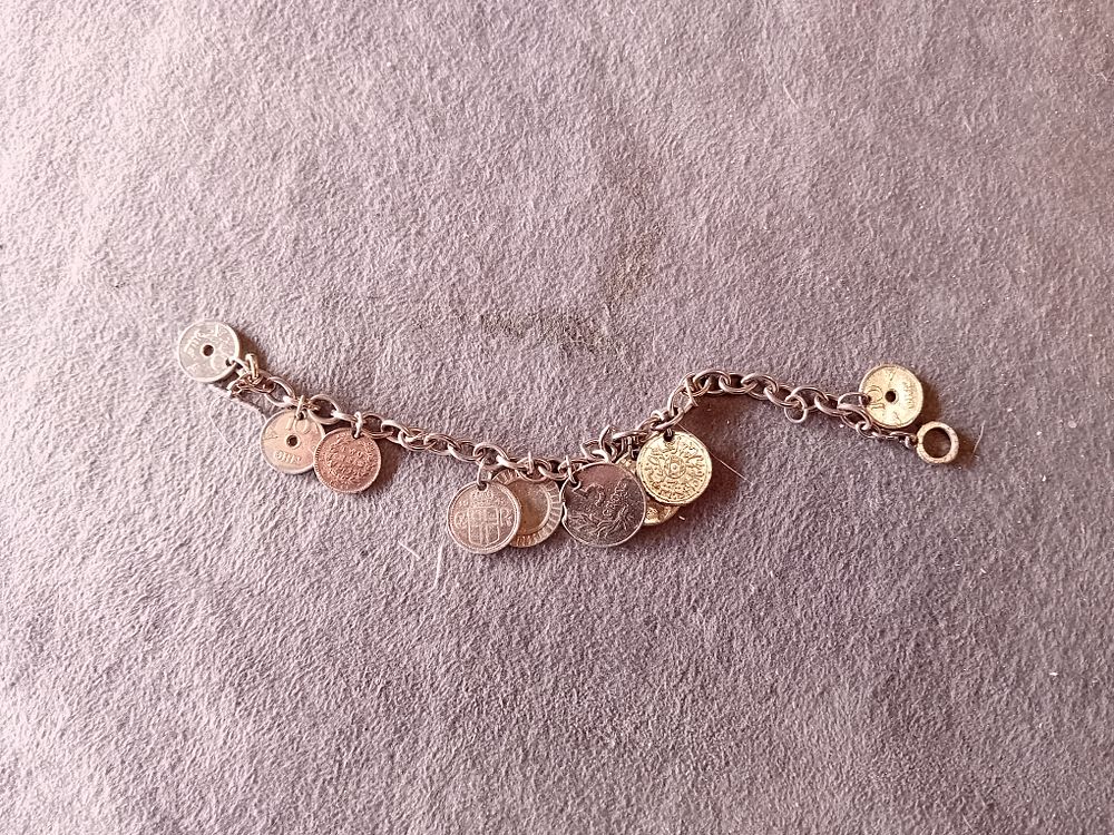 Lot 559: SILVER TONED INTERNATIONAL COIN AND TOKEN CHARM BRACELET