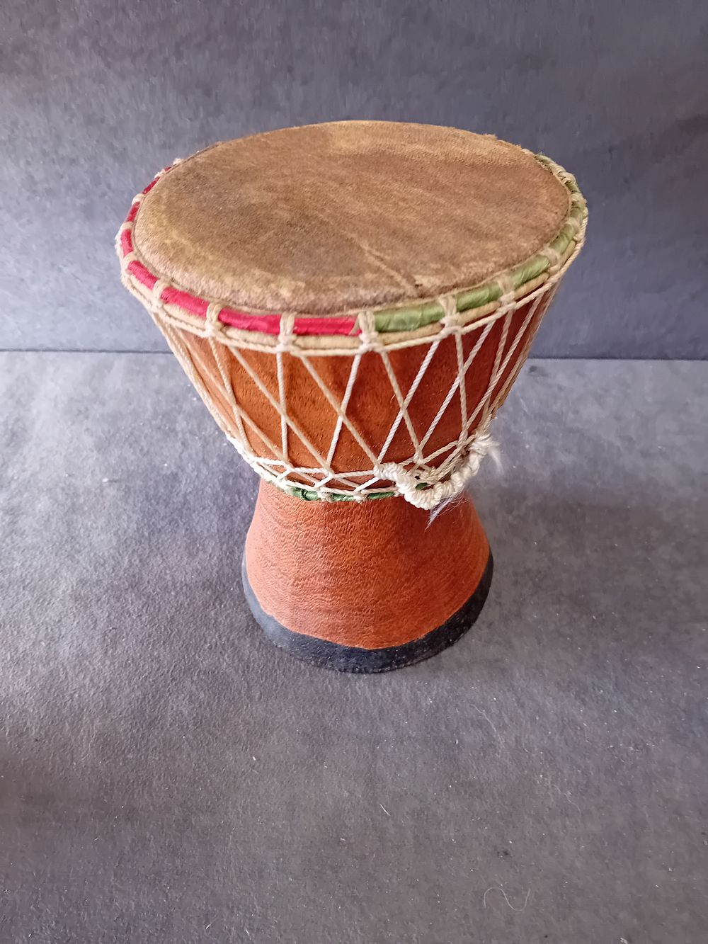 Lot 563: SMALL WOODEN HAND DRUM WITH LEATHER HEAD AND ROPE TENSIONING