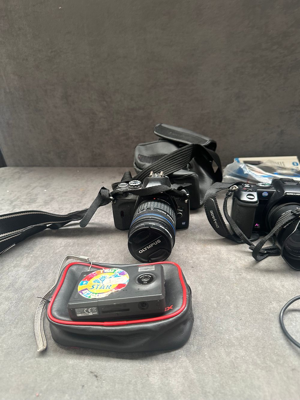 Lot 354: An Assortment of Digital Cameras and Accessories Including Olympus Konica Minolta and Fujifilm Models