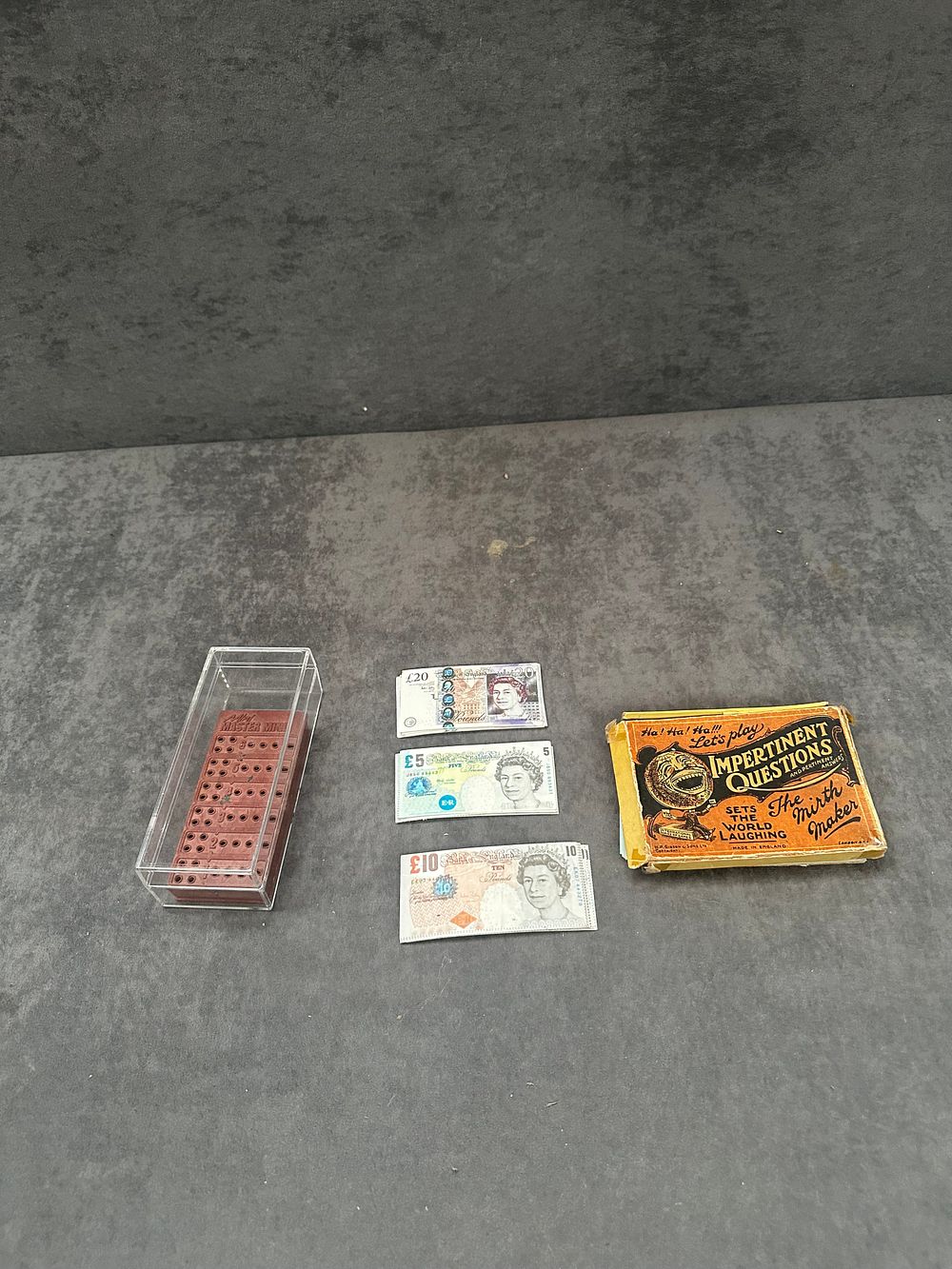 Lot 239: An H. P. Gibson and Sons Card Game, Travel Mastermind, and Novelty Toy Currency