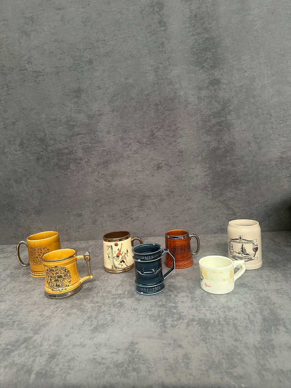 Lot 434: A Collection of Seven Commemorative and Souvenir Miniature Ceramic Tankards and Mugs