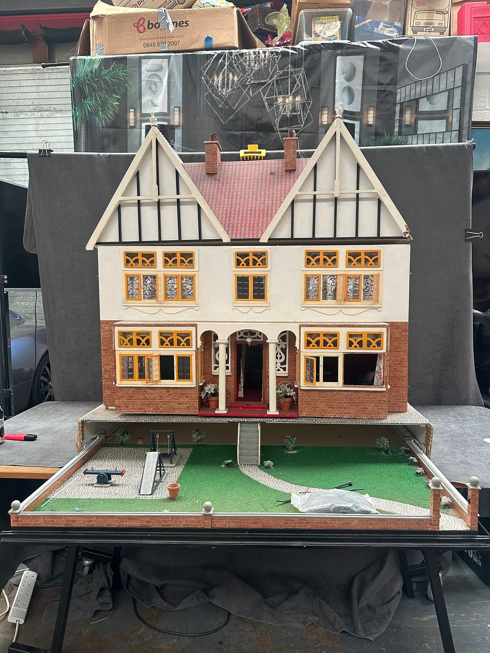 Lot 5: A large vintage wooden mock-Tudor dollhouse with integrated garden and an assortment of miniature furniture