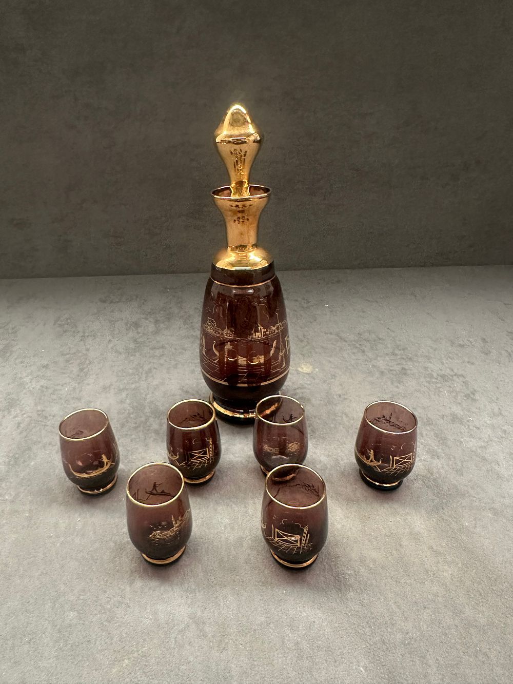 Lot 654: A Vintage Burgundy and Gilt Glass Liqueur Set