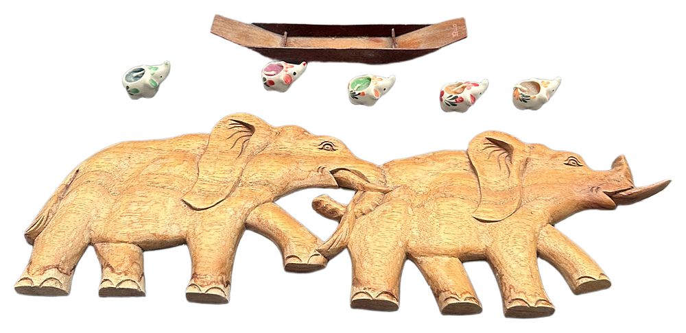 Lot 632: A Collection of Carved Wooden Elephant Wall Plaques, Miniature Ceramic Elephant Candle Holders, and a Wooden Boat Model
