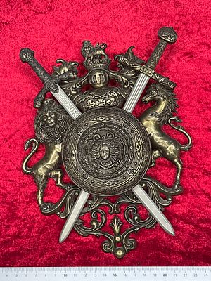 פאנל דקורטיבי הרלדִי. Decorative wall plaque with crossed swords, a shield, and heraldic 