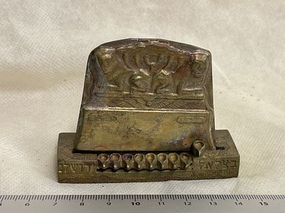 חנוכיית וינטג’ עם תבליט מנורה. חנוכייה מתכתית קטנה עם עיטור תבליט מינימליסטי וכיתובים “ירושלים” 
