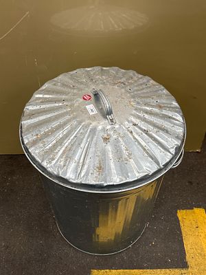 A Large Galvanised Steel Corrugated Dustbin with Matching Lid. A large tapered cylindrical 