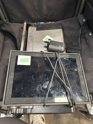 A Black Smart Home Tablet Device and a Rotary Paper Trimmer. A black digital tablet device and a 