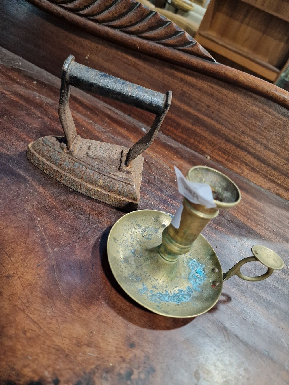 Lot 839: A Late Victorian Cast Iron Sad Iron and a Brass Chamberstick