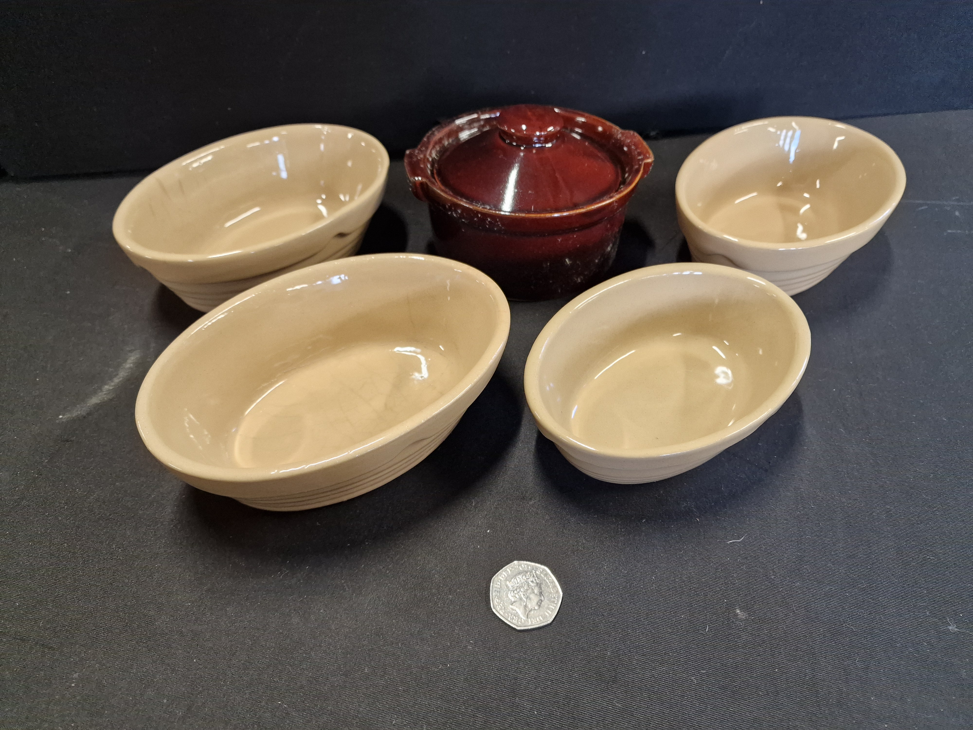 A Collection of Glazed Earthenware Kitchenware Including Four Oval Baking Dishes and a Lidded Casserole Pot