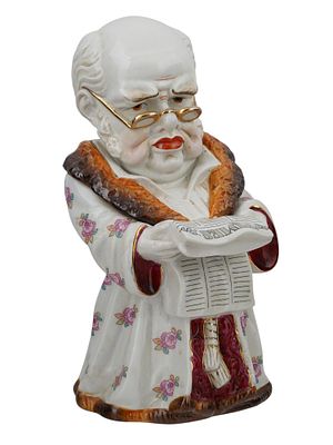 A CONTINENTAL PORCELAIN TOBACCO JAR OF A MAN READING THE TIMES, CA. 1900. A whimsical and