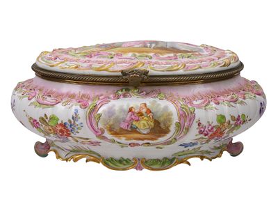 A BRASS-MOUNTED DRESDEN PORCELAIN BOX. Of large oval form, finely hand-painted with panels of 