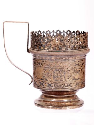 A RUSSIAN PAN-SLAVIC STYLE ENGRAVED SILVER TEA GLASS HOLDER. Of cylindrical form on a spreading 