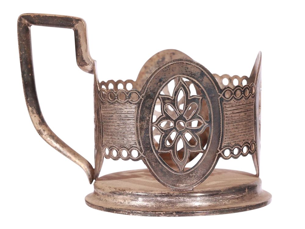 A RUSSIAN ENGRAVED SILVER TEA GLASS HOLDER. Of circular form with a raised base and a shaped 
