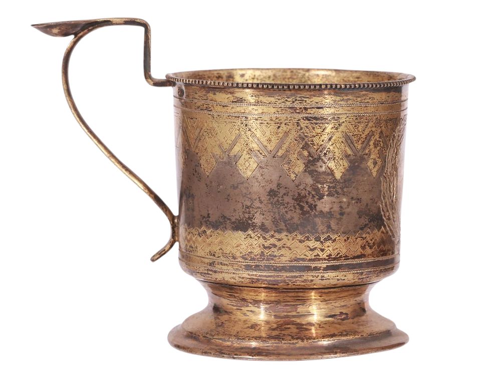 A RUSSIAN PARCEL-GILT SILVER TEA GLASS HOLDER WITH PAN-SLAVIC STYLE ETCHING. Of classical 