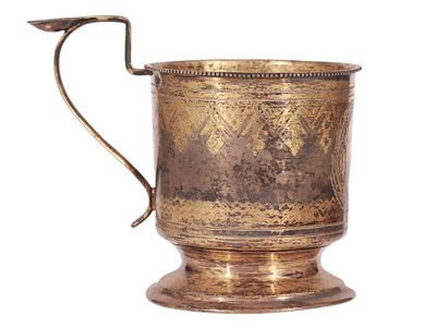 A RUSSIAN PARCEL-GILT SILVER TEA GLASS HOLDER WITH PAN-SLAVIC STYLE ETCHING. Of classical 