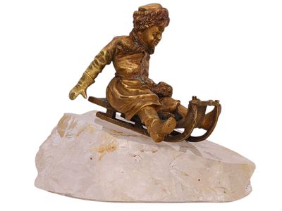A RUSSIAN BRONZE FIGURE OF A PEASANT BOY ON A SLED MOUNTED ON A ROCK CRYSTAL, LATE 19TH CENTURY. 