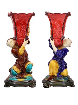 A PAIR OF CHINESE GLAZED PORCELAIN VASES, CA. 1900. Each modeled as a kneeling figure supporting 