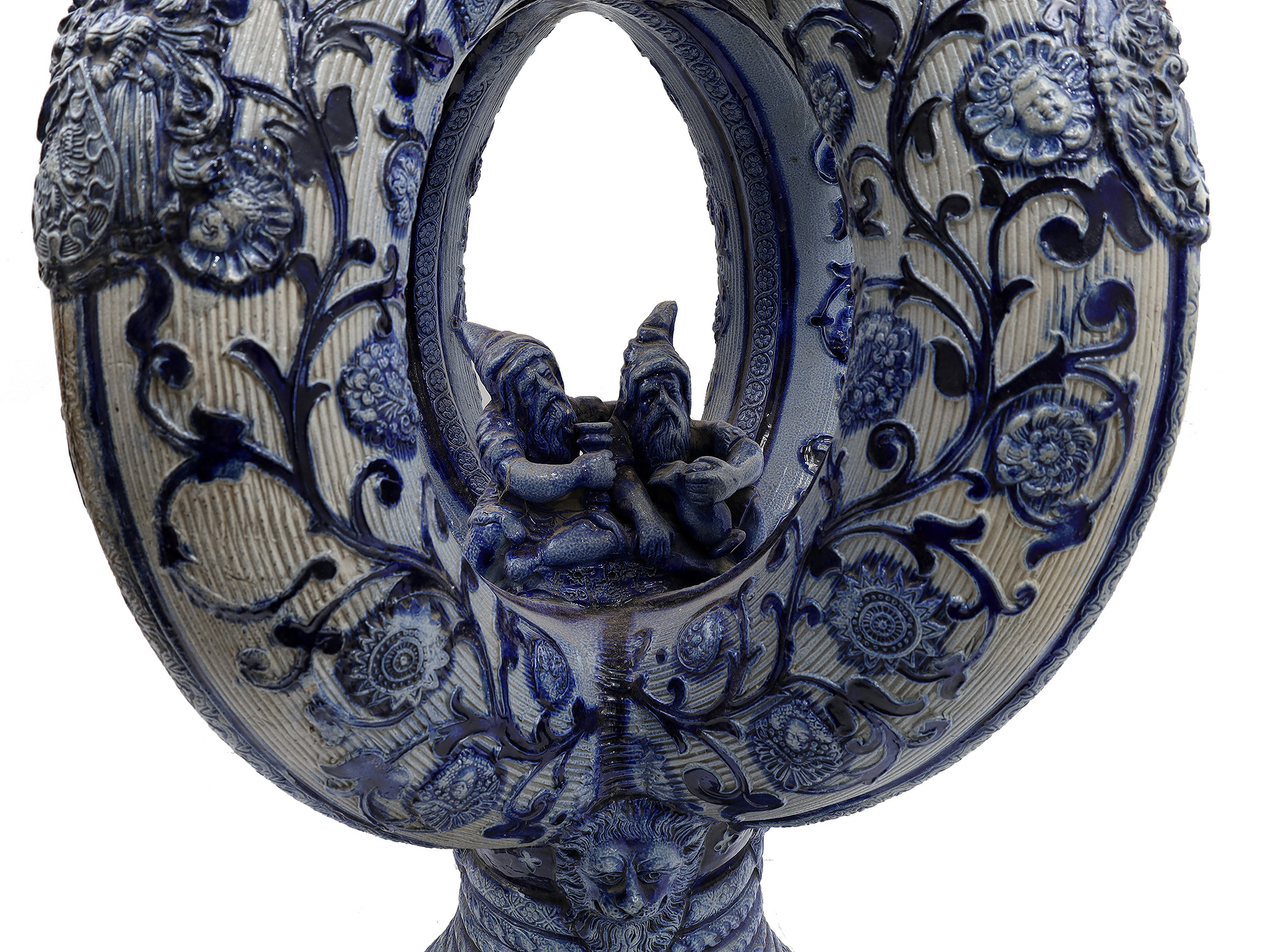 A GERMAN GLAZED CERAMIC PRETZEL EWER WITH DWARFS