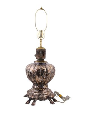 A SILVERED LAMP WITH COW FEET, CONVERTED TO ELECTRIC, PROBABLY GERMAN. A large silver lamp that 