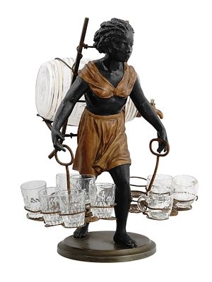 A PAINTED METAL FIGURAL LIQUOR DISPENSER WITH CUT AND ETCHED GLASS DECANTER AND CUPS, CIRCA 1900. 