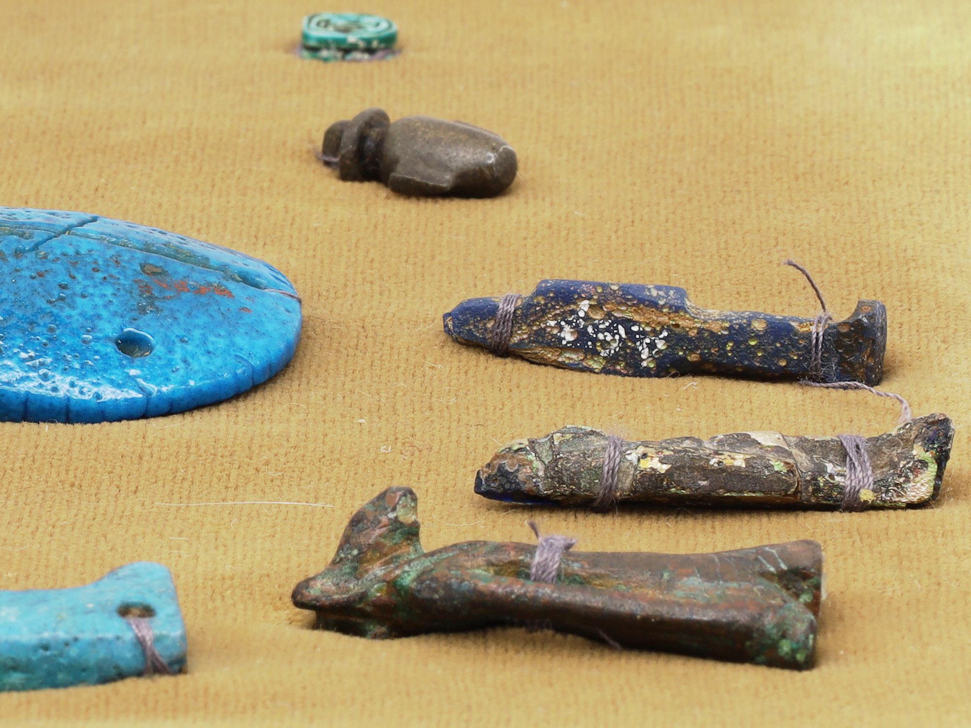 A GROUP OF 12 ANCIENT EGYPTIAN FAIENCE, STEATITE AND BRONZE AMULETS