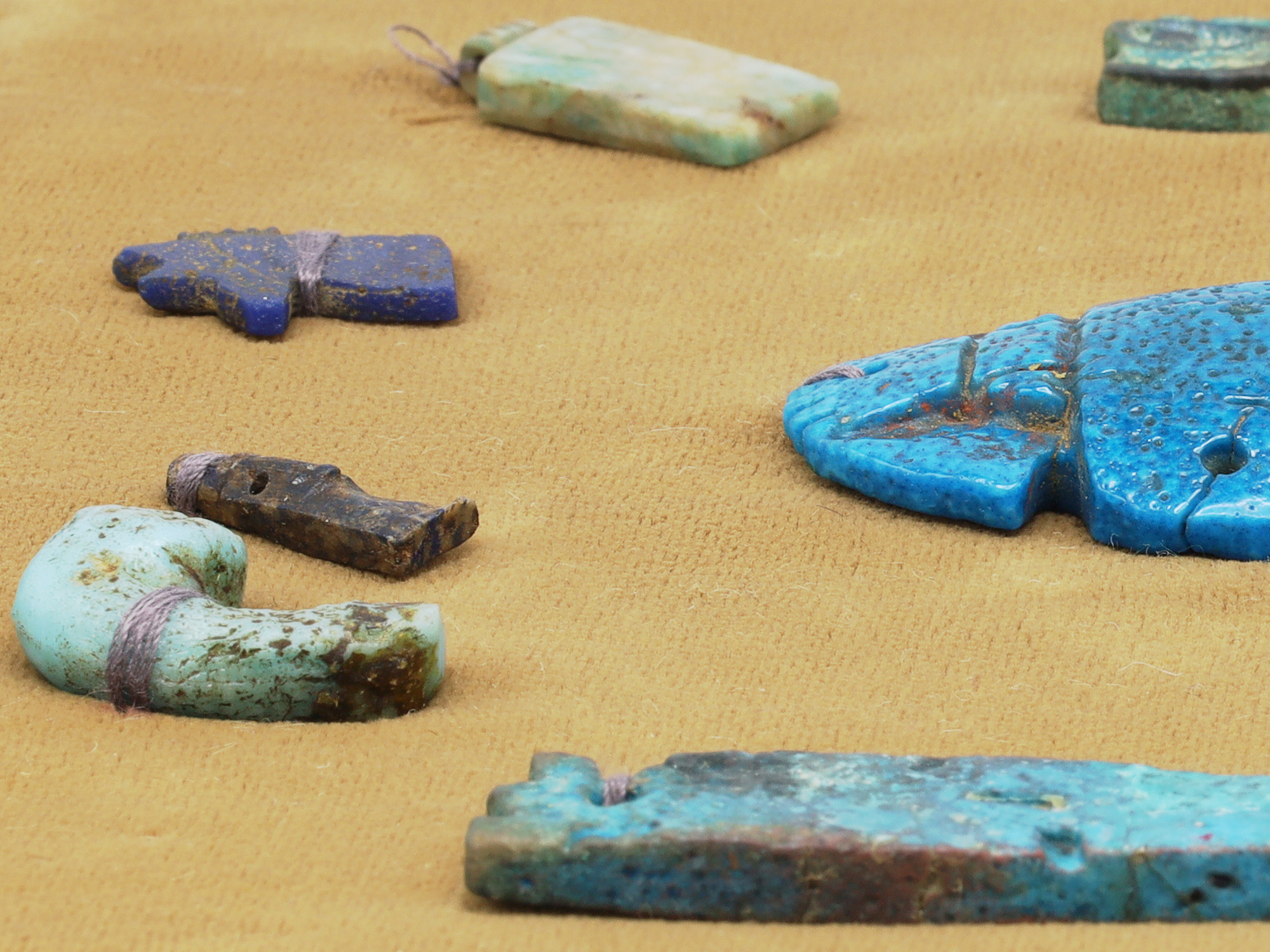 A GROUP OF 12 ANCIENT EGYPTIAN FAIENCE, STEATITE AND BRONZE AMULETS