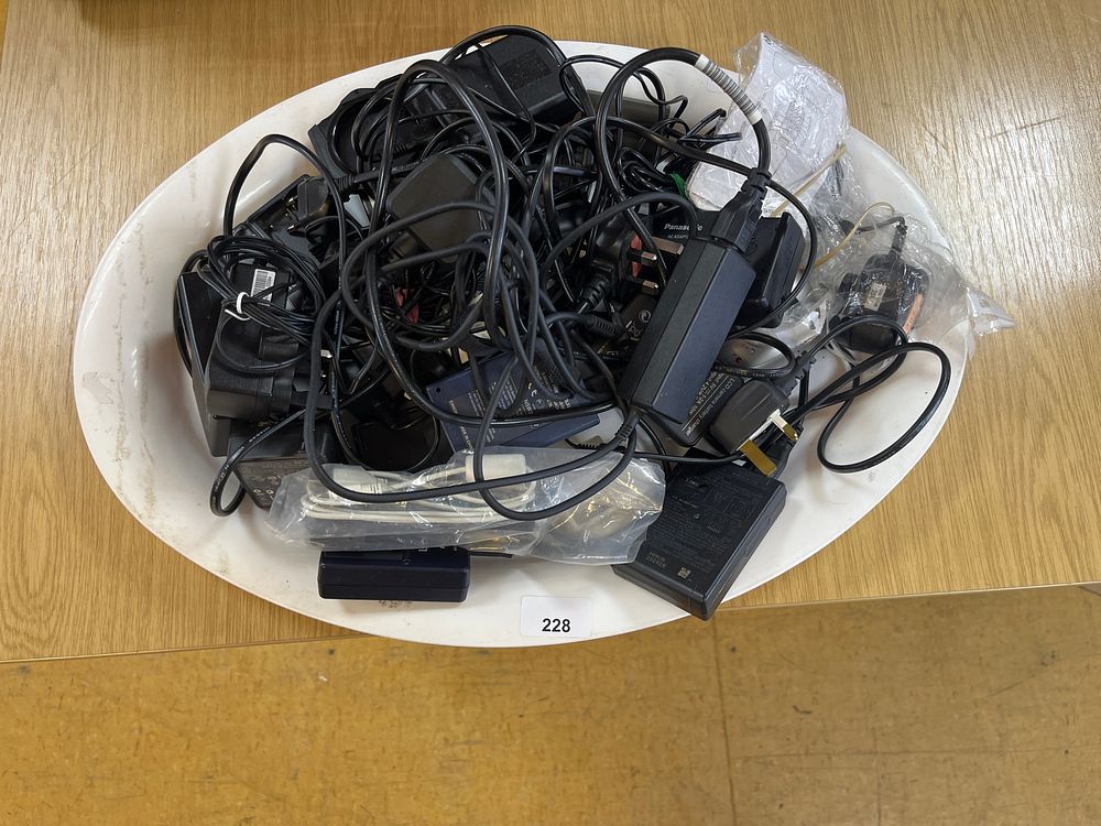 Lot 228: A tray of camera power packs and leads....
