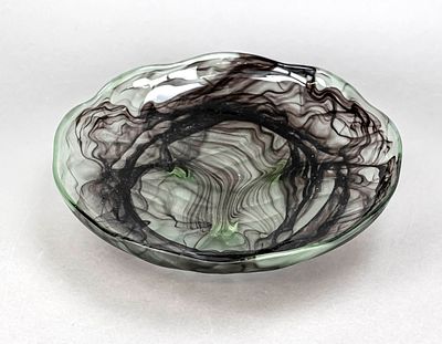 Round bowl, 20th century, on 3 feet, flat shape, wavy rim, gray-greenish glass with violet 