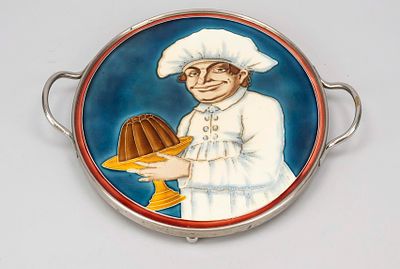 Cake plate tray, circa 1900, polychrome glazed ceramic, relief depiction of a baker holding a 