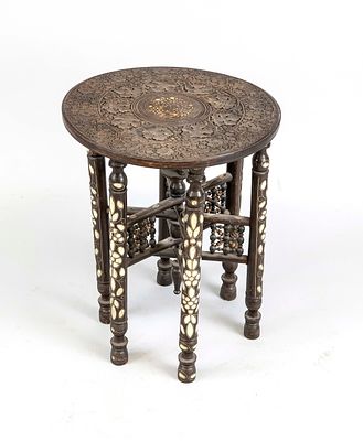 Folding table, North Africa, 20th century, wood with inlaid legs. Round, carved tabletop on an 