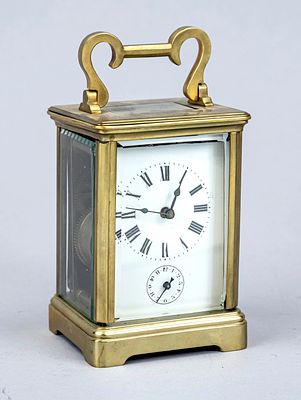 Travel alarm clock circa 1900, brass case, faceted glass on all sides, top-mounted crown, white 