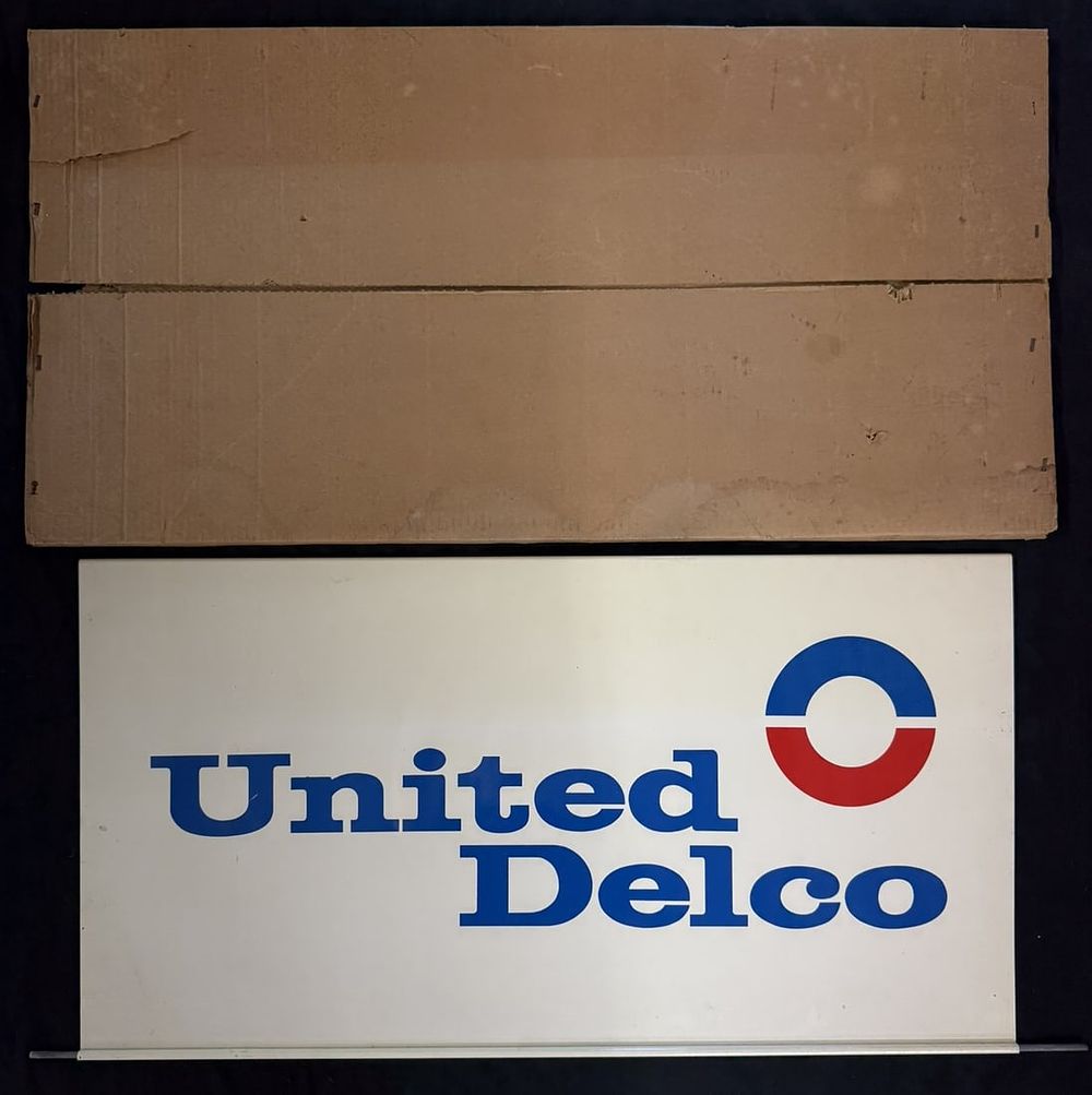 Lot 293: NOS United Delco DST Painted Metal Hanging Sign w/ Box