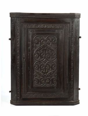 A 19TH CENTURY CARVED OAK HANGING CORNER CUPBOARD with panelled door (71cm across 92cm high )