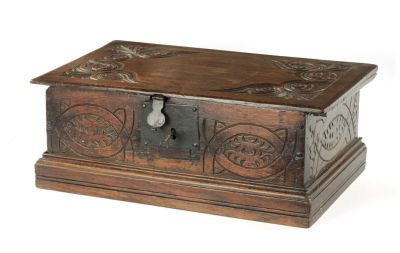 A LATE 17TH CENTURY CARVED OAK DEED BOX with hinged lid and iron strapwork hinges and lock 