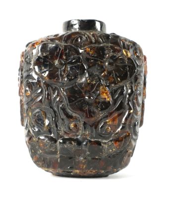 A CHINESE CARVED AMBER SNUFF BOTTLE with floral decoration (7.5cm high)