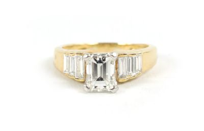 A STYLISH 18CT GOLD SEVEN STONE DIAMOND RING having a four-claw raised 'Tiffany' setting with 